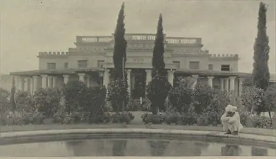The Subadar's residence, a house with cypress trees behind a pool.