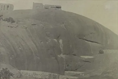 A great smooth dome of rock with buildings on its top.