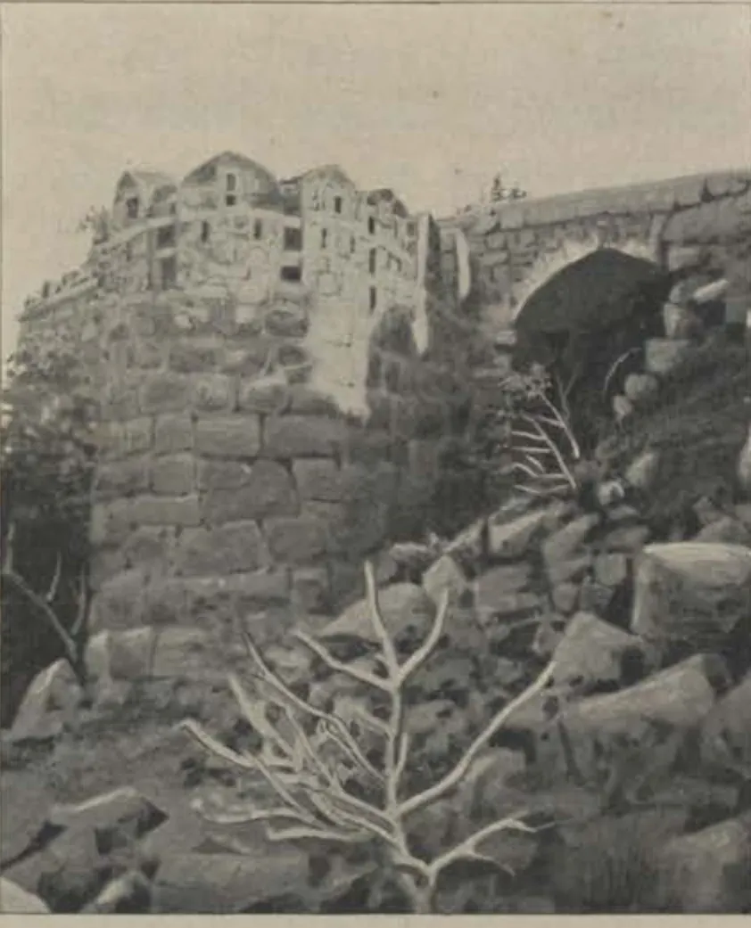 A ruined bastion and an arched gateway among rocks.