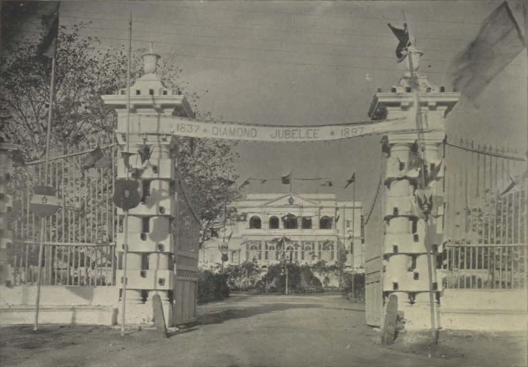A decorated gateway with a Diamond Jubilee banner, and the guest house beyond.