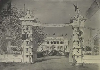 A decorated gateway with a Diamond Jubilee banner, and the guest house beyond.