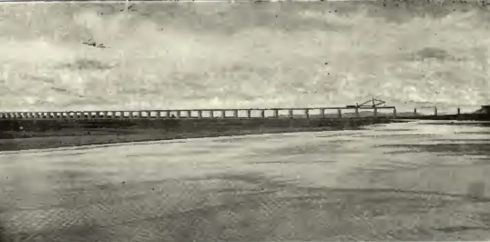 A long railway bridge with many spans crossing the wide Godavari river.