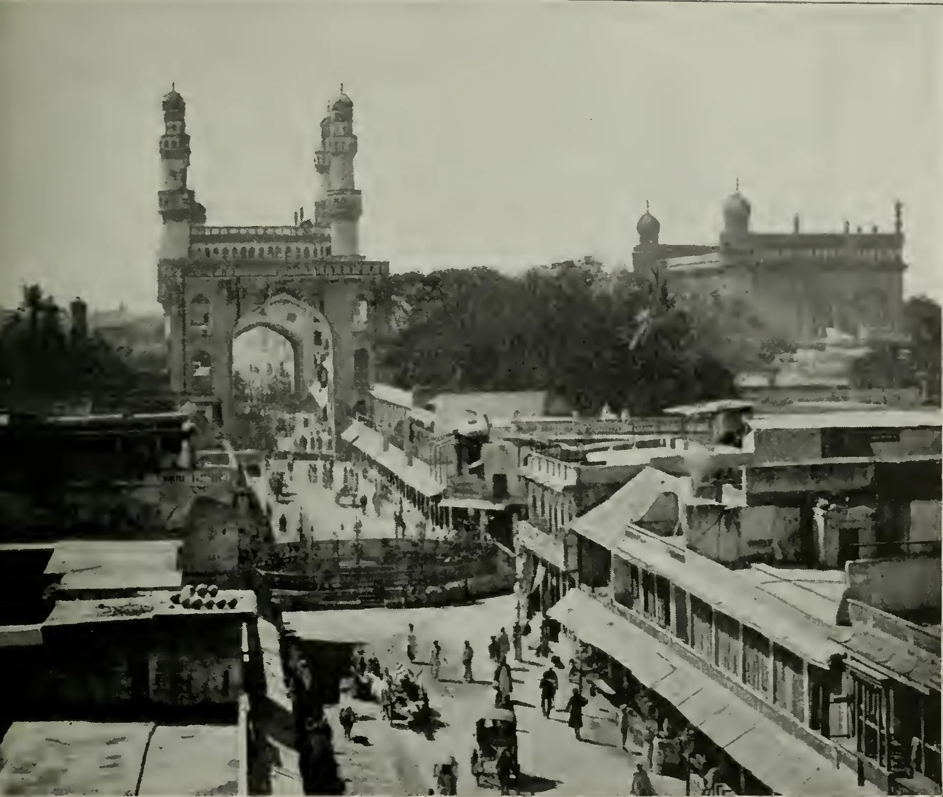Bird's-eye view down a busy main street of Hyderabad towards the Charminar, with the Mecca Masjid to the right behind.
