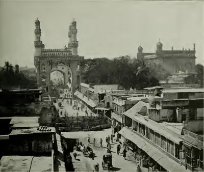 Bird's-eye view down a busy main street of Hyderabad towards the Charminar, with the Mecca Masjid to the right behind.