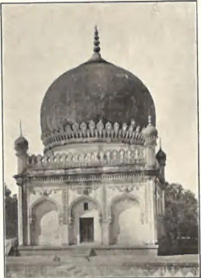 A domed building near the gate of the Golconda tombs, with a dark bulbous dome and arched walls.