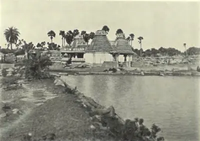 The Someswara temple at Panagal seen across a tank, with palm trees behind.
