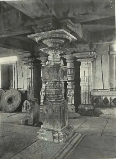 A carved pillar inside the Panchesvara temple at Panagal, with a millstone lying beside it.