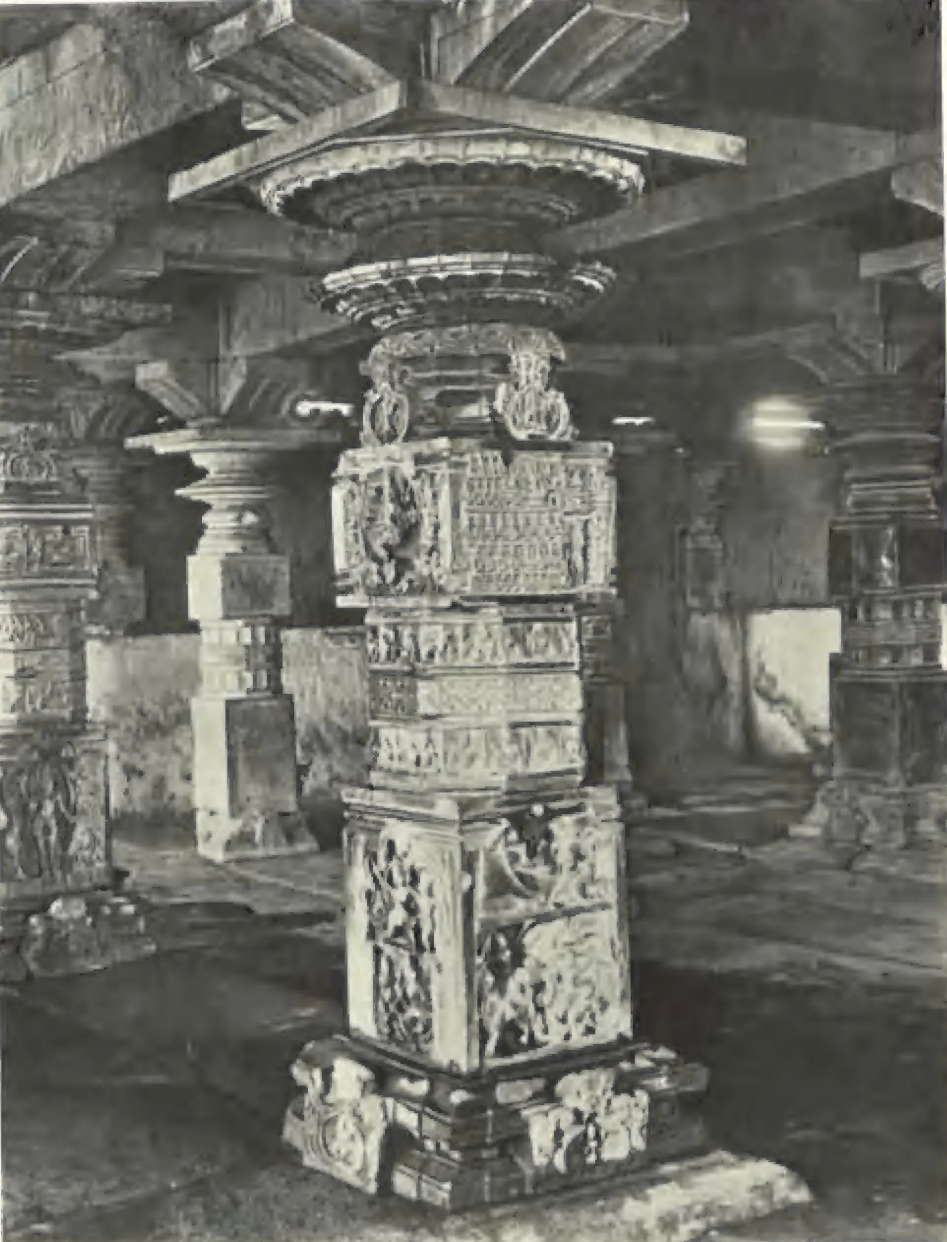 A richly carved pillar of the Someswara temple at Panagal, in a dim pillared hall.