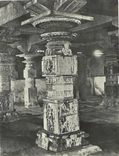 A richly carved pillar of the Someswara temple at Panagal, in a dim pillared hall.
