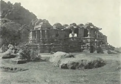 The Siva temple at Nagunur, a ruined temple on a platform below a rocky hill.