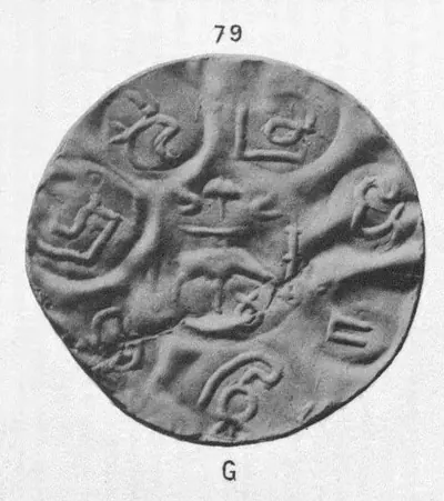 Photograph of a large, thin, wrinkled gold coin with several round punch-marks of letters and small emblems around a central mark; the plate number 79 above and the letter G (gold) below.