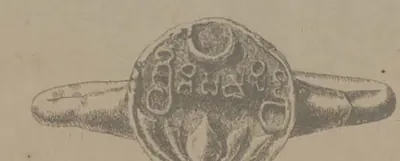 Drawing of a ring seen from the side with a round seal at its joint, bearing a crescent at the top, a line of letters and a lotus below.