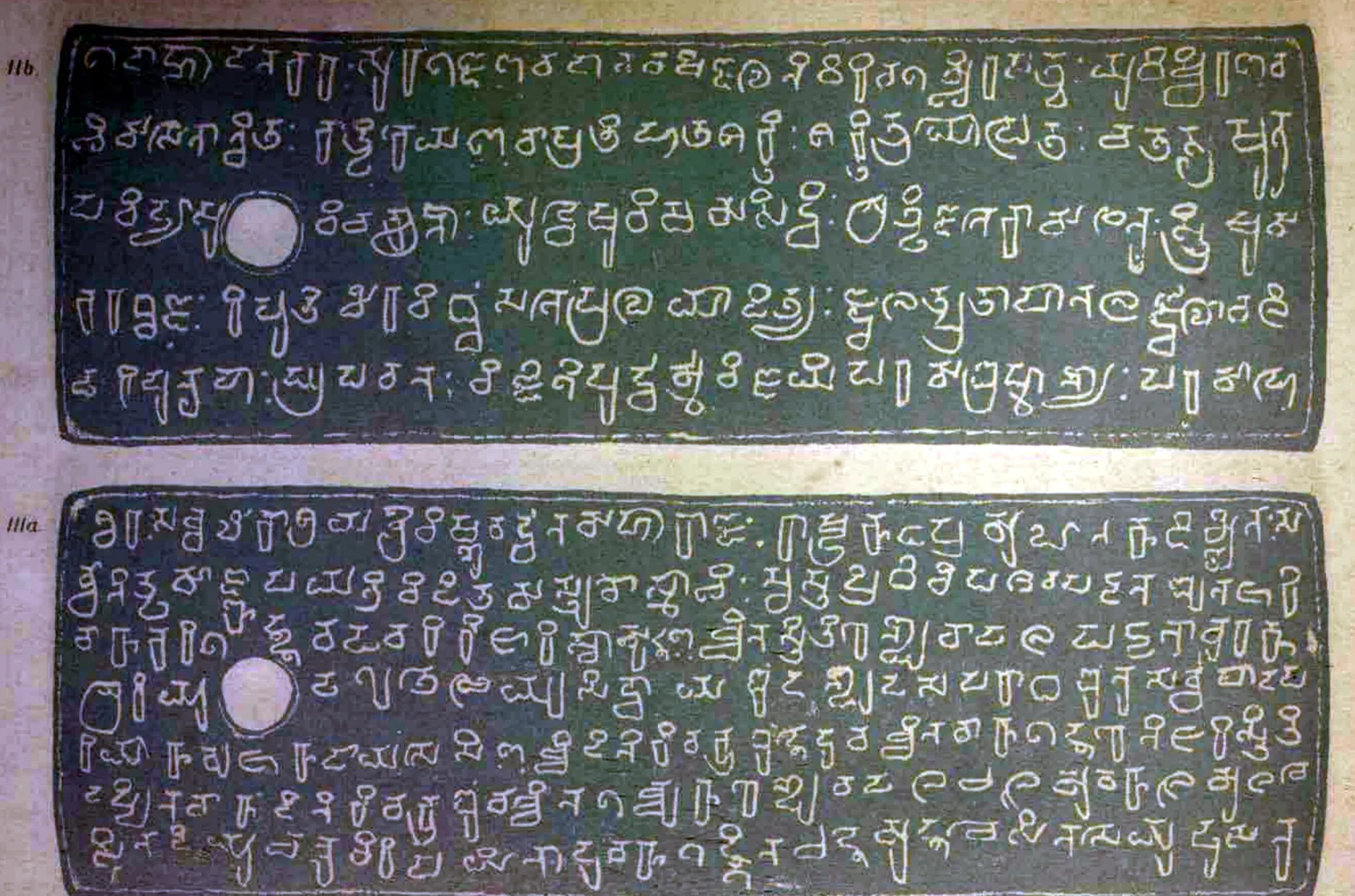 Ink impressions of two inscribed copper plates, the letters of the Telugu-Kannada script showing pale on a dark ground, each plate with a round ring hole near the left edge.