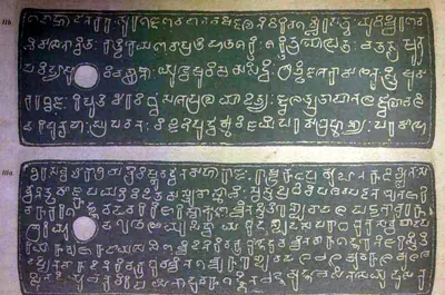 Ink impressions of two inscribed copper plates, the letters of the Telugu-Kannada script showing pale on a dark ground, each plate with a round ring hole near the left edge.