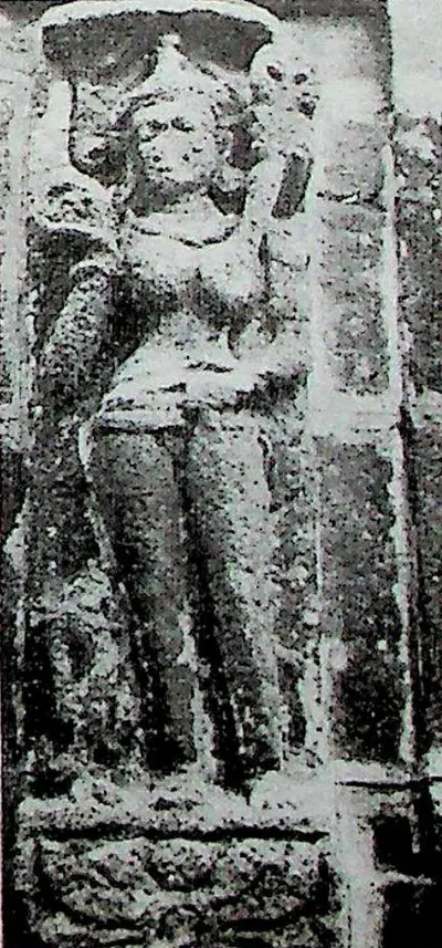 A narrow upright relief of a standing female figure with a tall headdress, in a gentle hip-shot pose.