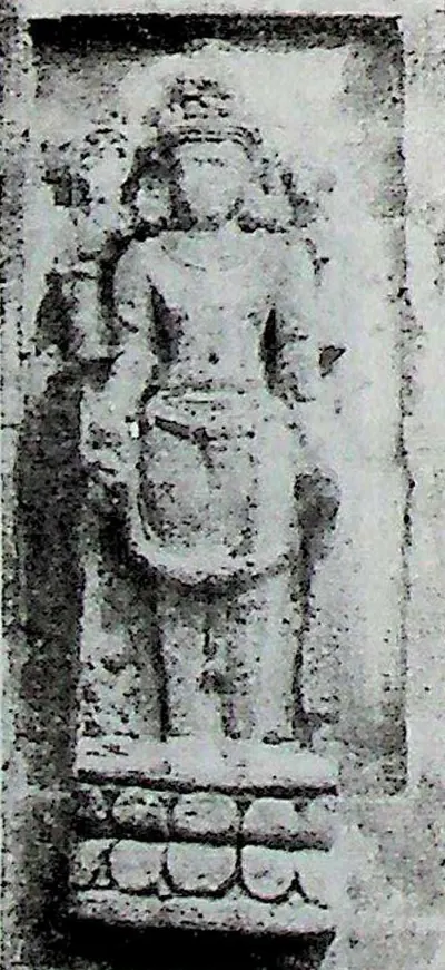 A small upright relief of a standing four-armed figure, identified as Vishnu, on a lotus pedestal.