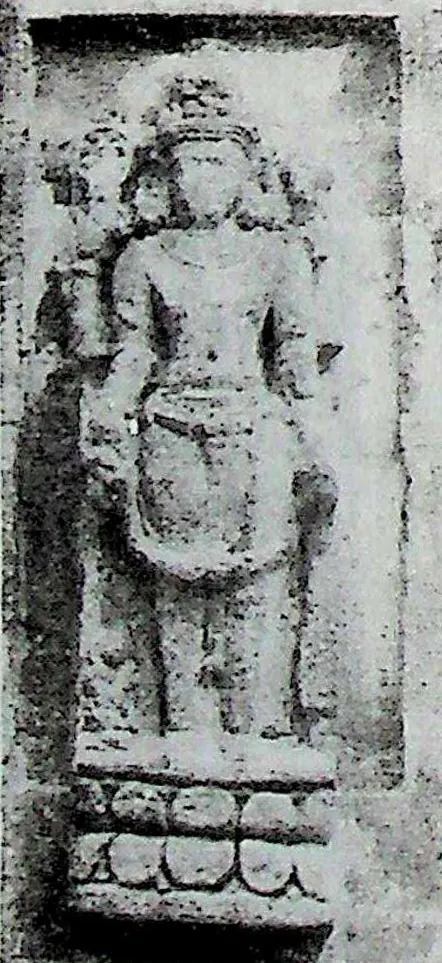 A small upright relief of a standing four-armed figure, identified as Vishnu, on a lotus pedestal.