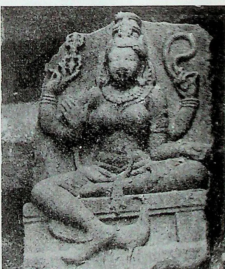 A seated goddess identified as Kaumari, with several arms and a tall crown, carved in high relief on a stone slab; a peacock below her.