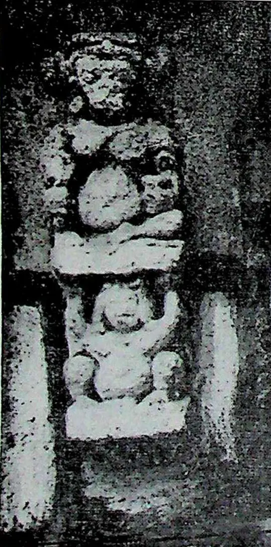A dark stone slab with a carved figure in a niche, identified in the caption as a bovine deity, with a second small figure below.