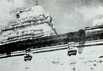 The upper part of the main shrine tower rising above a long sloping roofline, seen from a low angle against the sky.