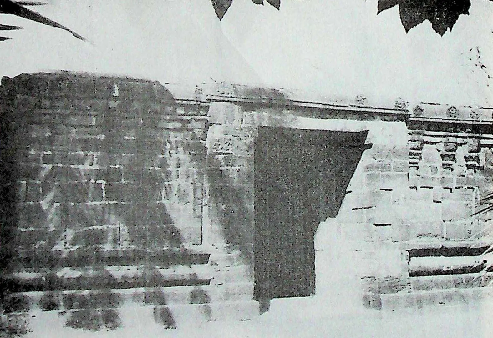 The northern entrance through the high stone wall of the outer enclosure at Chalukya Bhimavaram (Samalkot), with a dark doorway and stepped cornices.