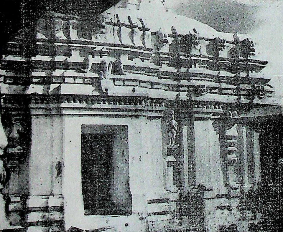 The south wall of a stone temple with a projecting doorway, pilasters and a cornice crowded with small roof mouldings and figures.
