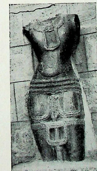 A headless and armless standing stone figure in a patterned lower garment, identified as Kumara.