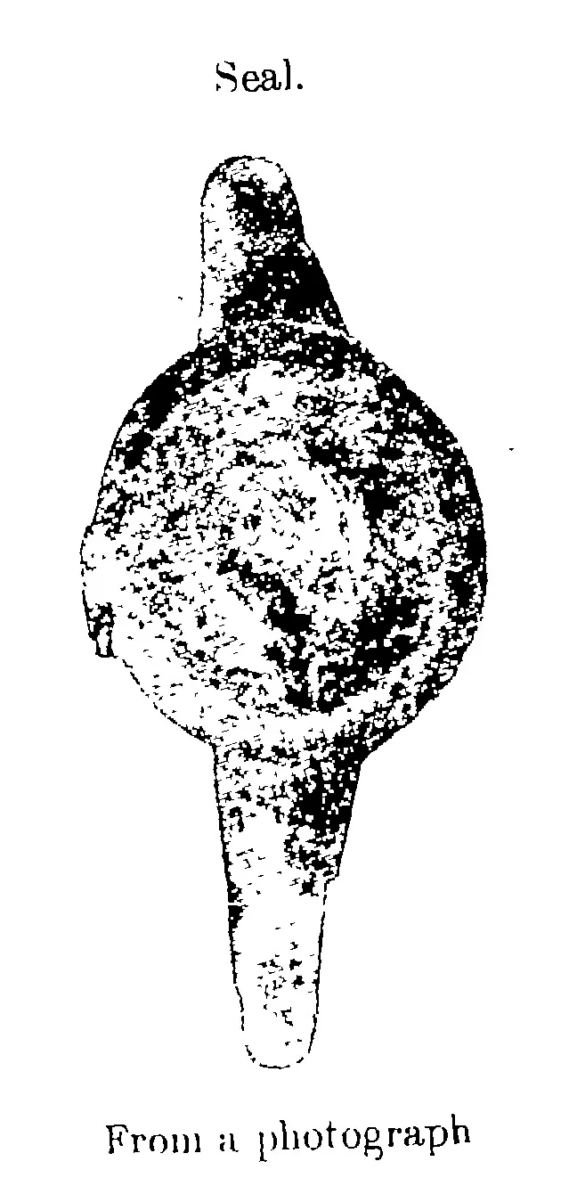 Photograph of an oval copper-plate seal on its ring, the ring ends rising above and below it; the seal face is worn and its emblem cannot be made out.
