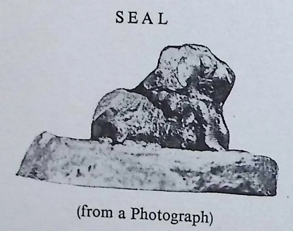 Photograph of a copper-plate seal seen obliquely from the side: a seated bull in relief standing up from a flat, round base.