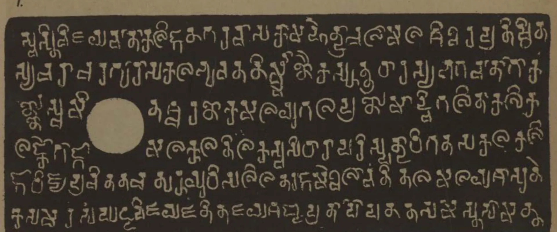 Lithograph of one copper-plate face, white letters on a dark grey ground: six lines of box-headed Kalinga-script letters with a white ring-hole at the left.