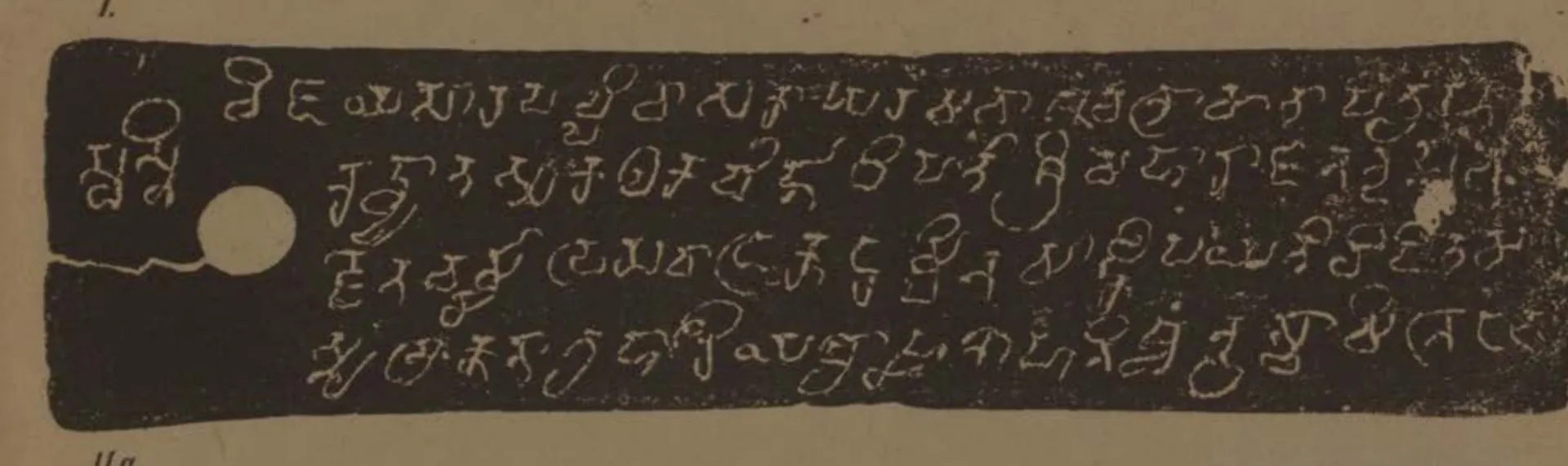 Lithograph of a narrow copper-plate face, pale letters on a dark grey ground: five lines of early box-headed letters with a white ring-hole at the left.