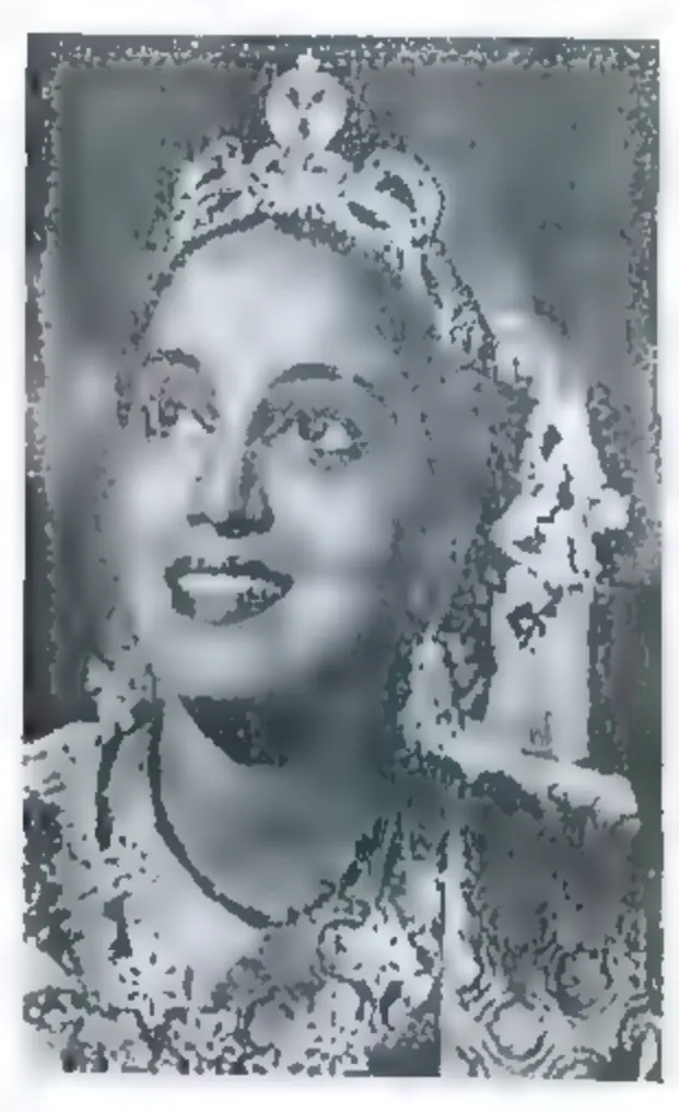 Black-and-white portrait of a smiling young woman wearing a tall jewelled crown and necklaces, looking up to the right.