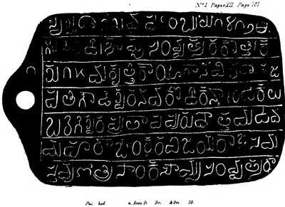 Lithograph of a copper plate with a rounded outline and a projecting tab with a ring-hole at the left, seven ruled lines of large white Telugu letters on black; small engraved lettering in the corners.
