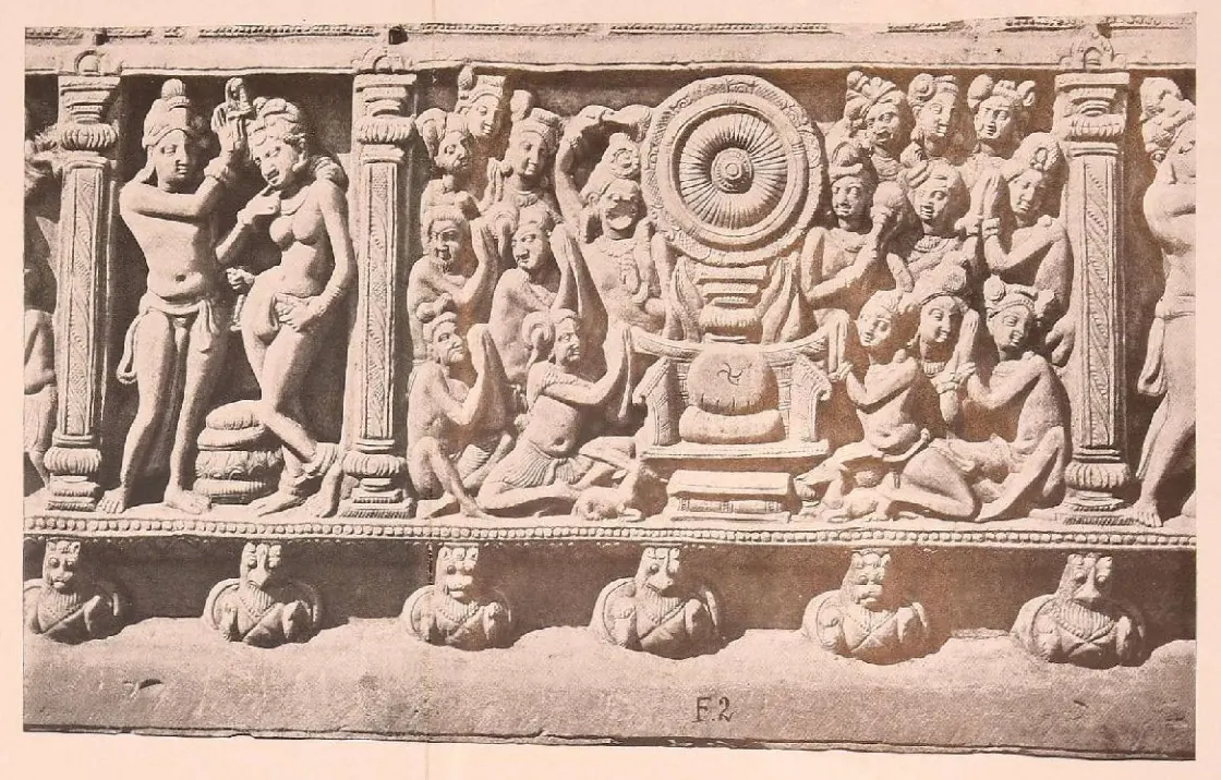 Carved frieze panel with a large wheel on a throne and kneeling worshippers.