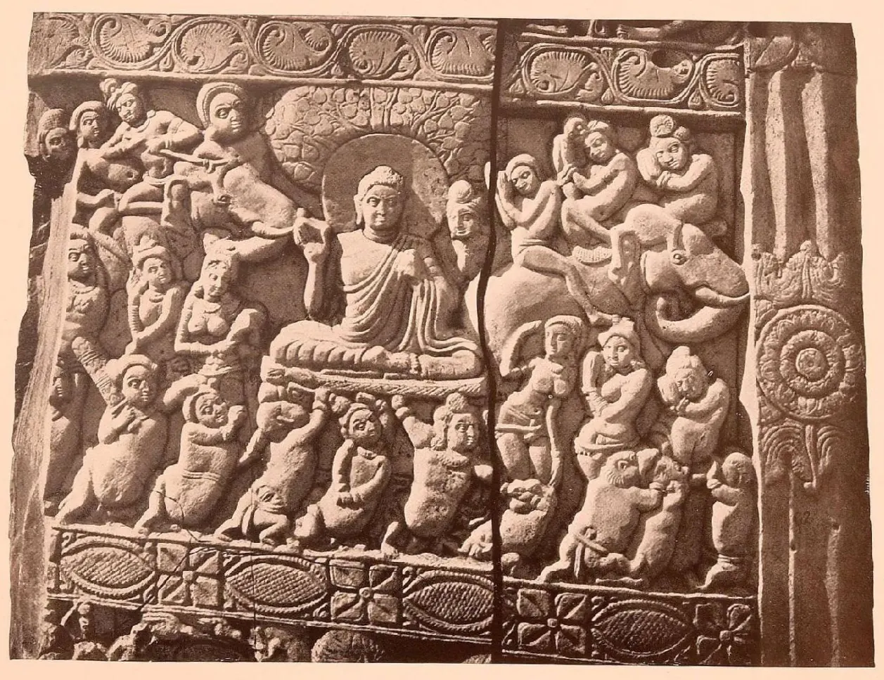 Carved relief of the Buddha seated under a tree, surrounded by crowded attacking and dancing figures.