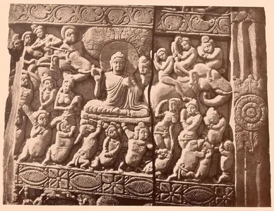 Carved relief of the Buddha seated under a tree, surrounded by crowded attacking and dancing figures.