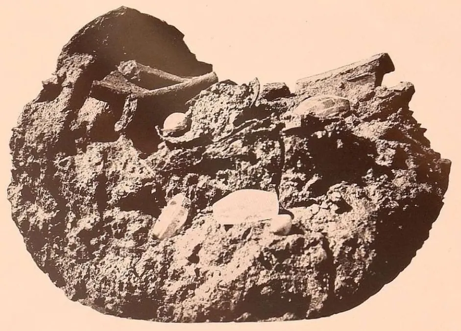 A lump of earth and broken brick with the relic deposit as it was found.