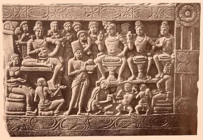Carved relief of seated figures on thrones above and attendants below, framed by pilasters.