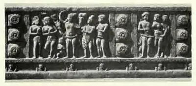 Long carved beam panel with a procession of figures between rows of lotus roundels.