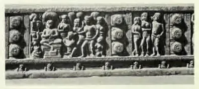 Long carved beam panel with groups of figures between rows of lotus roundels.