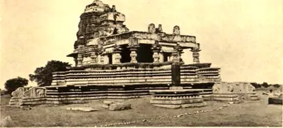 A stone temple with a pillared hall and a ruined stepped tower on a broad moulded platform in open ground.