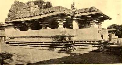A flat-roofed pillared hall with deep eaves on a plain platform, the roof edge broken and overgrown.