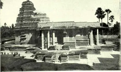 The Ramappa temple after repair: a pillared hall on a stepped platform with the stepped tower behind and palm trees at the right.