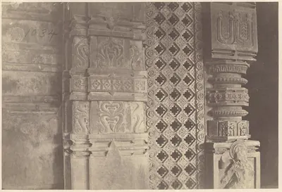 Close view of a carved door jamb, a pierced stone screen with a lattice pattern and a carved pillar; the number 1034 is written on the print.