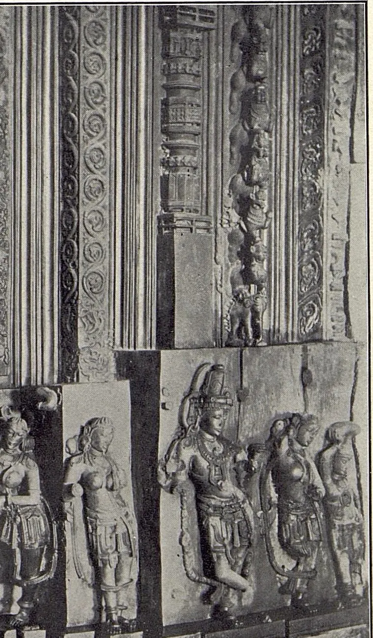 Part of a carved door jamb: vertical bands of scrollwork above a row of standing figures in relief.