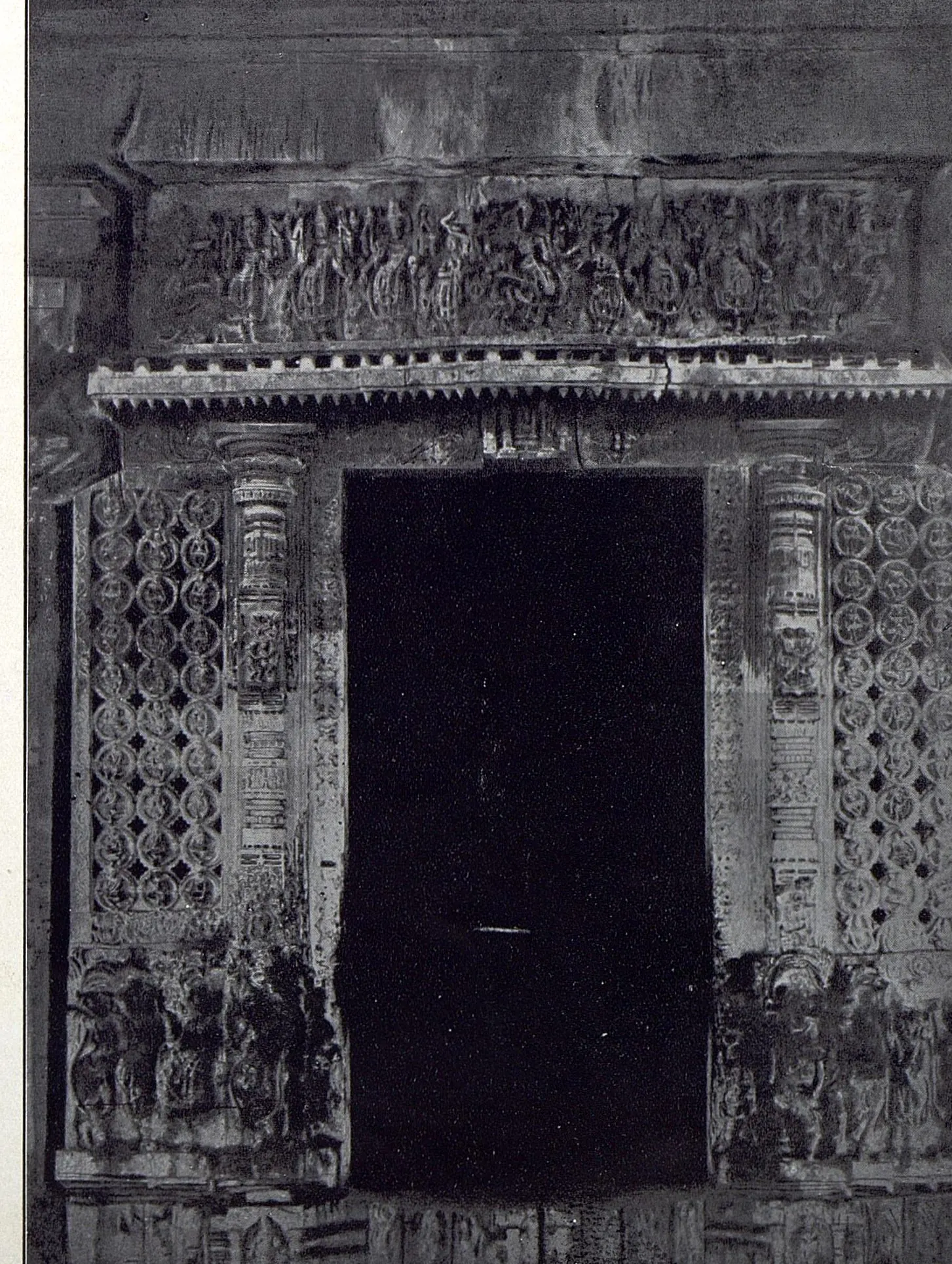 The shrine doorway of the Ramappa temple: a dark opening framed by carved jambs and pierced stone screens, under a lintel carved with a frieze of small figures.