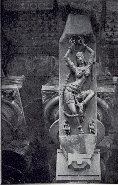 A slanting stone bracket carved with a dancer whose arms are raised above her head, with two small figures at her feet, above a pillar capital.
