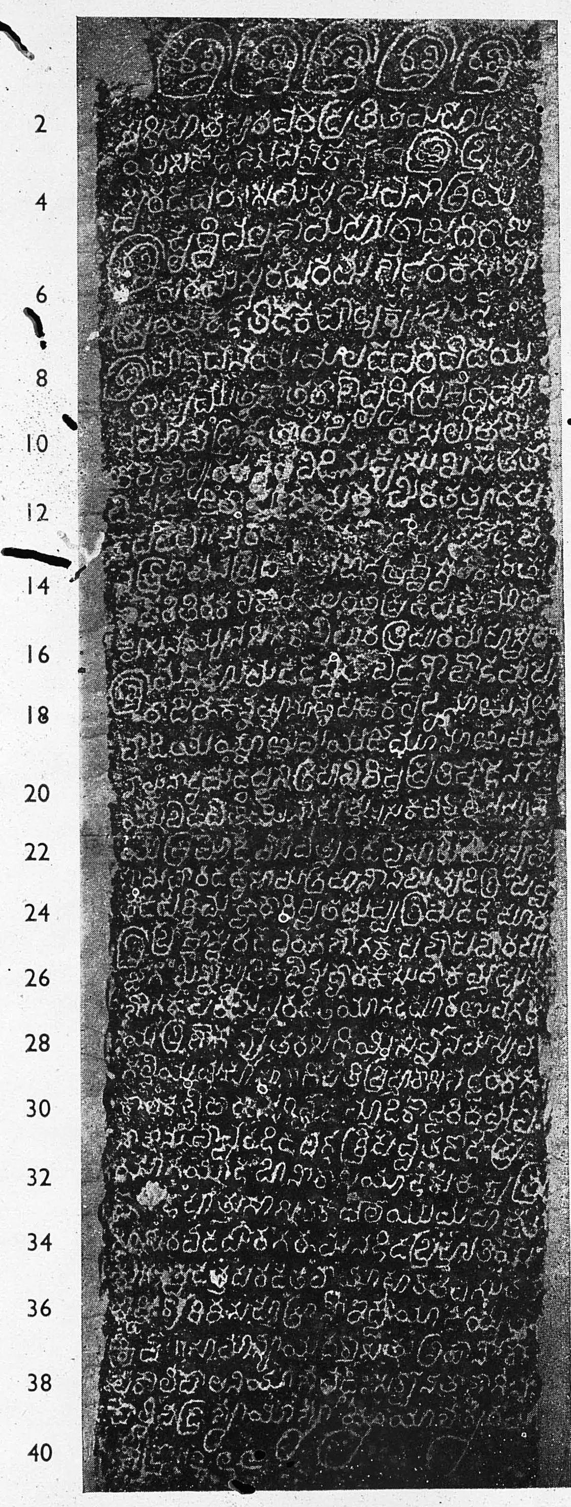 Ink impression of a tall, narrow inscribed slab, white Kannada letters on black, forty lines numbered in the left margin; the first line is a row of five large ornamental letters (sri) and the last line ends in looped ornaments.