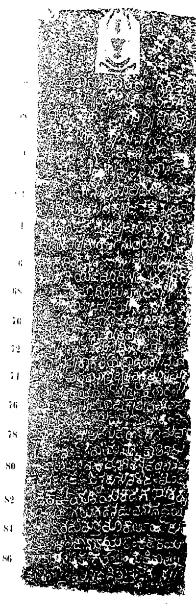 Ink impression of one face of an inscribed pillar: a seated Jaina figure at the top above about thirty rows of worn Kannada letters, white on a speckled ground, with line numbers in the left margin.