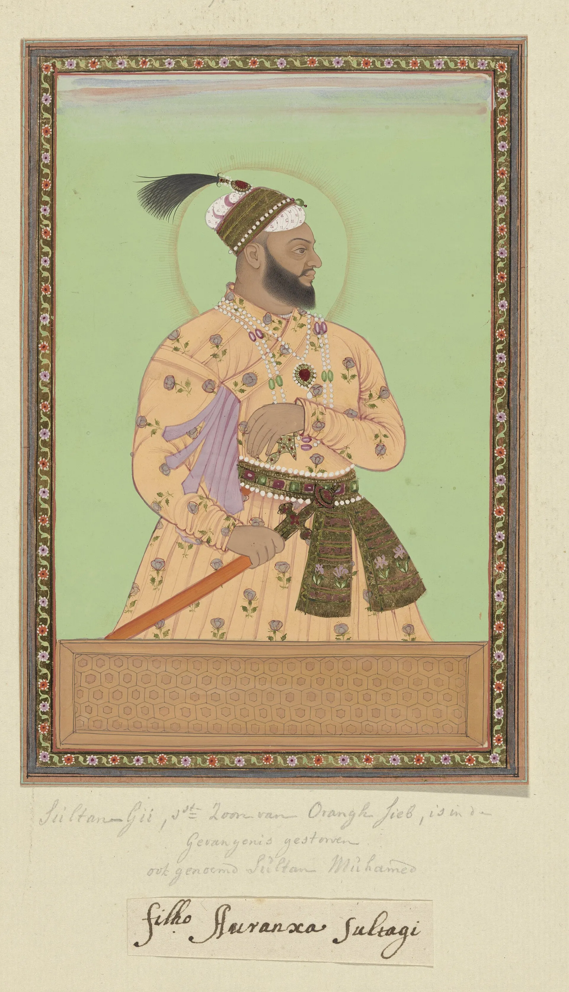 Deccani painting of a bearded man in a patterned orange robe and plumed turban, standing in profile with a halo against a green ground, in a decorated border with handwritten notes below.